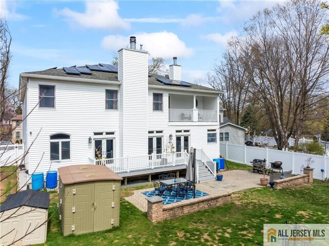 11 Hilltop Blvd N, East Brunswick, NJ 08816 - back of house with a balcony, a patio area, solar panels, and a chimney