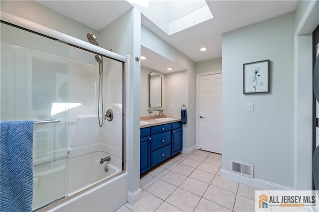 11 Hilltop Blvd N, East Brunswick, NJ 08816 - full bathroom with a skylight, double vanity, bath / shower combo with glass door, tile patterned flooring, and baseboards