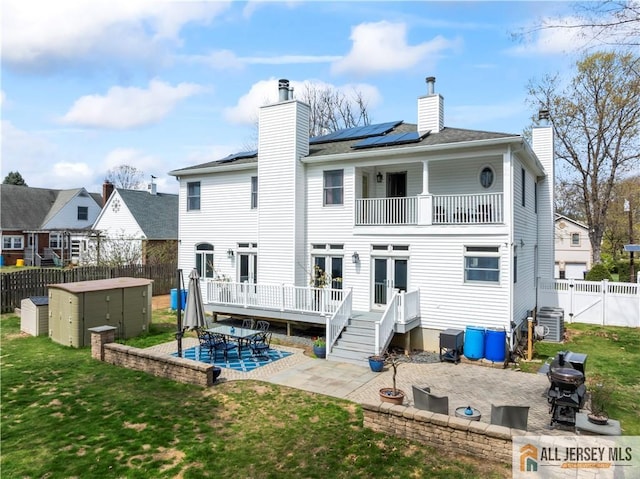 11 Hilltop Blvd N, East Brunswick, NJ 08816 - back of house featuring a balcony, a patio area, solar panels, central air condition unit, and a chimney