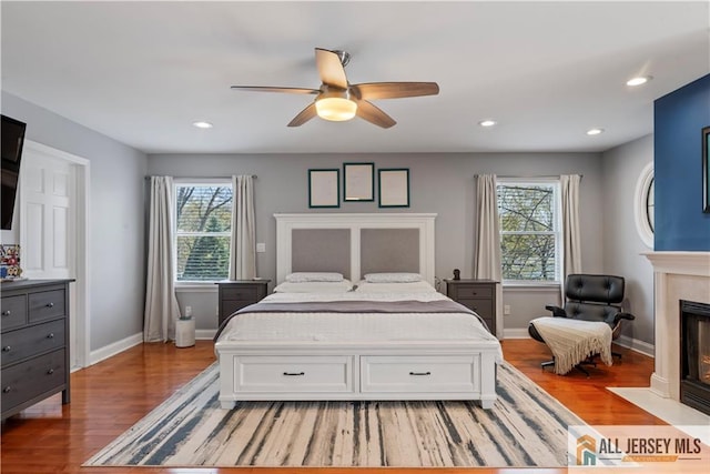 11 Hilltop Blvd N, East Brunswick, NJ 08816 - bedroom featuring multiple windows, light wood-style flooring, a fireplace with flush hearth, and recessed lighting