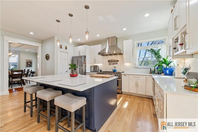 11 Hilltop Blvd N, East Brunswick, NJ 08816 - kitchen with wall chimney exhaust hood, stainless steel appliances, light wood-style floors, decorative backsplash, and recessed lighting