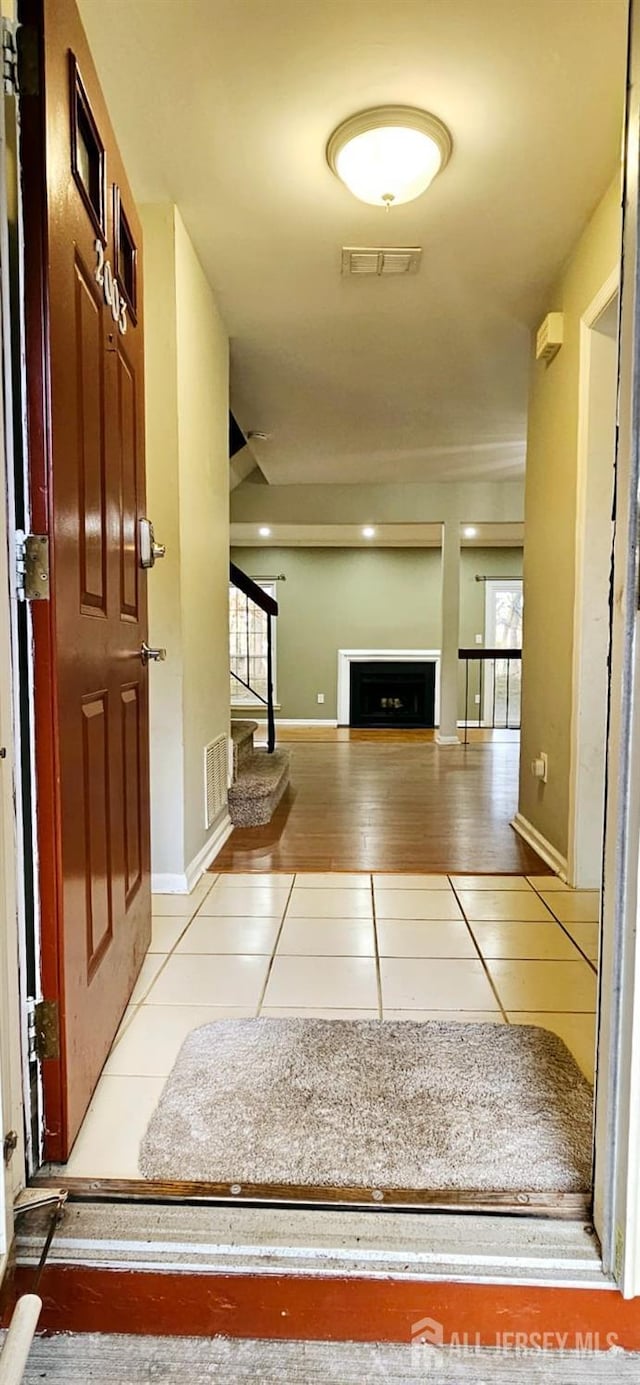 interior space with visible vents, stairway, and tile patterned floors