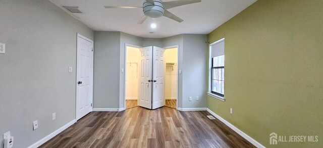 2003 Timber Oaks Rd, Edison, NJ 08820 - unfurnished bedroom featuring wood finished floors, a walk in closet, and ceiling fan