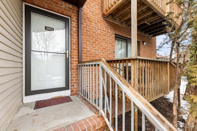 view of exterior entry featuring brick siding