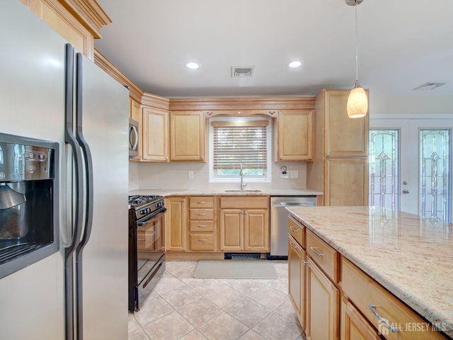 kitchen featuring light tile patterned floors, appliances with stainless steel finishes, light stone countertops, light brown cabinets, and a sink