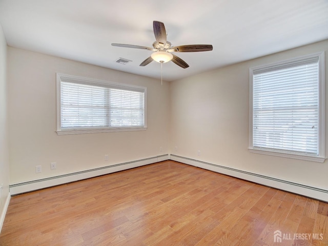 spare room with visible vents, ceiling fan, and wood finished floors