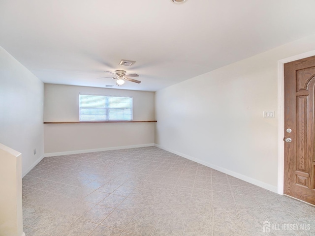 spare room featuring visible vents, ceiling fan, and baseboards