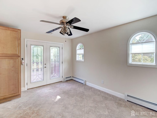 spare room with french doors, baseboard heating, a ceiling fan, and baseboards