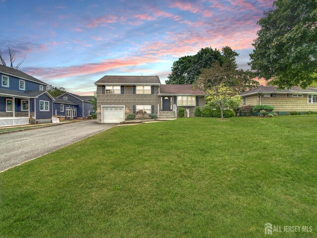 split level home featuring a lawn and a garage