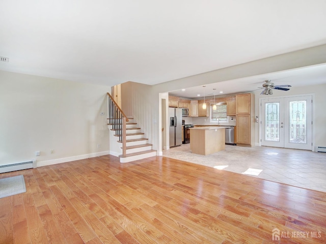 unfurnished living room featuring baseboards, light wood-style flooring, stairway, baseboard heating, and a baseboard heating unit