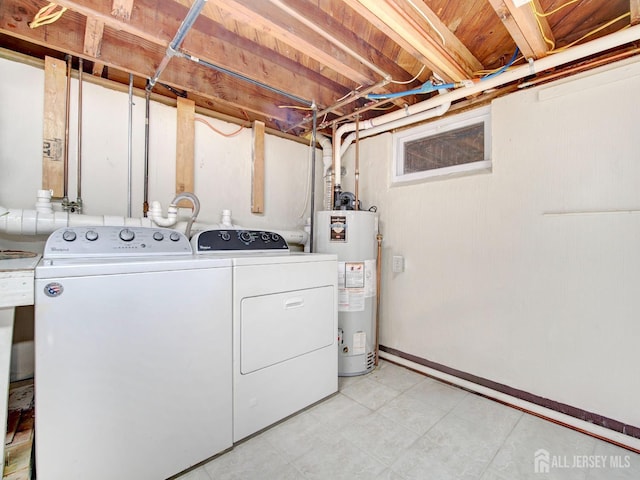 laundry room featuring laundry area, baseboards, light floors, washing machine and dryer, and water heater