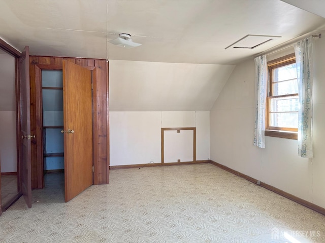 additional living space featuring baseboards and lofted ceiling