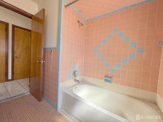 full bath with tile patterned floors, bathing tub / shower combination, and tile walls