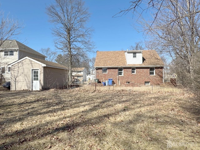 back of property featuring brick siding and an outbuilding