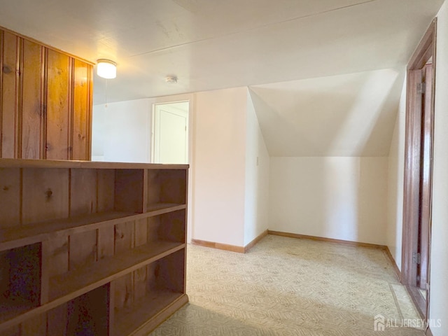 additional living space with baseboards, carpet flooring, and vaulted ceiling