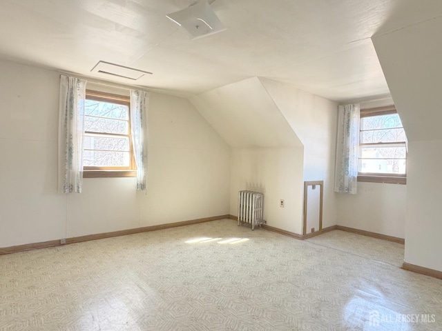 additional living space with lofted ceiling, radiator, and baseboards