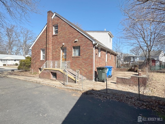 exterior space featuring brick siding and a chimney