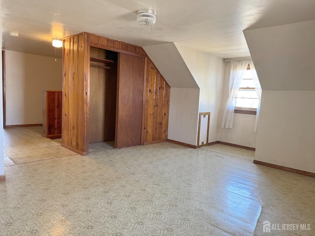 bonus room featuring baseboards and vaulted ceiling