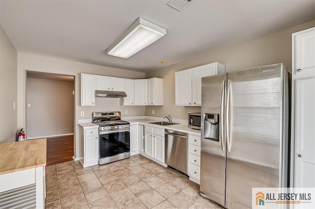 1804 Pheasant Run, South Brunswick, NJ 08852 - kitchen with appliances with stainless steel finishes, under cabinet range hood, a sink, light countertops, and white cabinetry