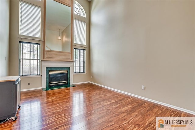 1804 Pheasant Run, South Brunswick, NJ 08852 - unfurnished living room with wood finished floors, a high ceiling, a fireplace, and baseboards