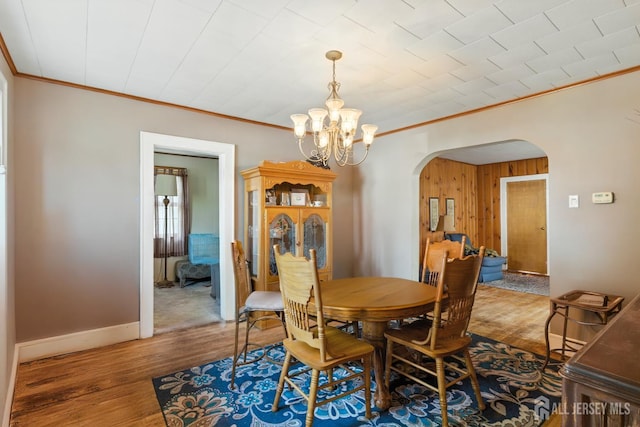 139 Palmer Ave, South Plainfield, NJ 07080 - dining room featuring arched walkways, ornamental molding, a chandelier, wood finished floors, and wood walls
