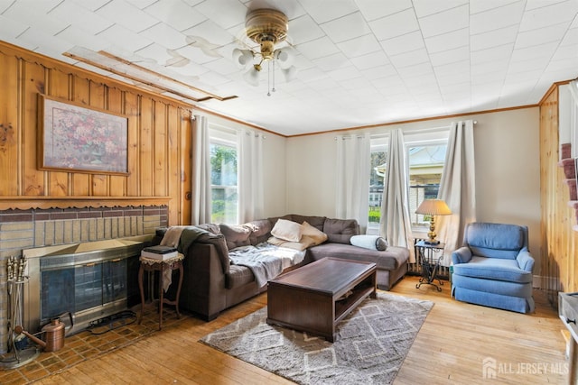 139 Palmer Ave, South Plainfield, NJ 07080 - living room featuring crown molding, light wood finished floors, ceiling fan, wooden walls, and a fireplace