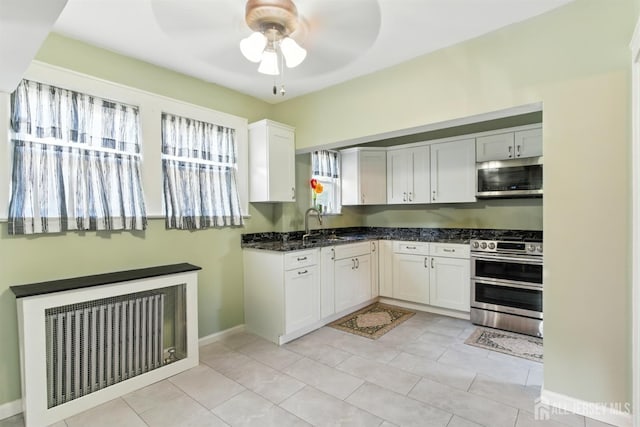 139 Palmer Ave, South Plainfield, NJ 07080 - kitchen with stainless steel appliances, ceiling fan, white cabinets, radiator, and dark stone countertops
