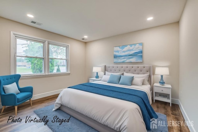 bedroom with baseboards, wood finished floors, and recessed lighting