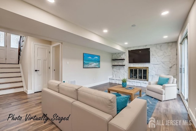 living room with wood finished floors, baseboards, stairway, and recessed lighting