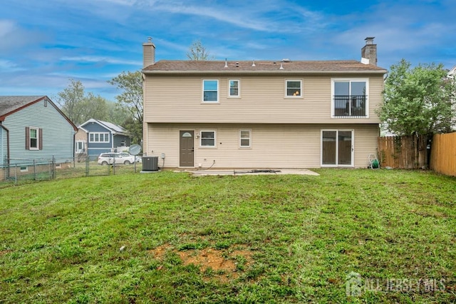 rear view of property featuring a chimney, central AC unit, and a patio area