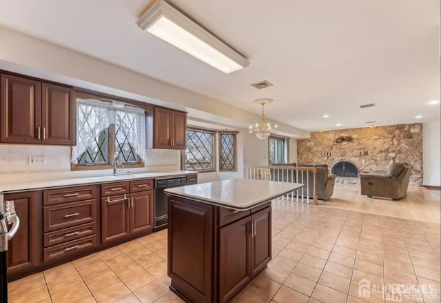 6 Persimmon Ct, East Brunswick, NJ 08816 - kitchen with dishwasher, a chandelier, light countertops, light tile patterned floors, and a stone fireplace