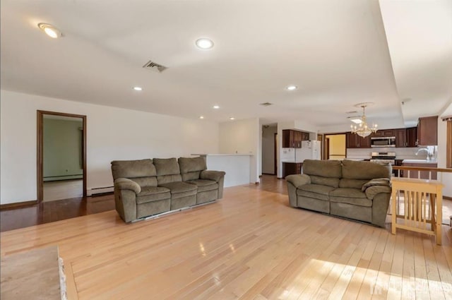 6 Persimmon Ct, East Brunswick, NJ 08816 - living room featuring a chandelier, a baseboard heating unit, light wood finished floors, and recessed lighting