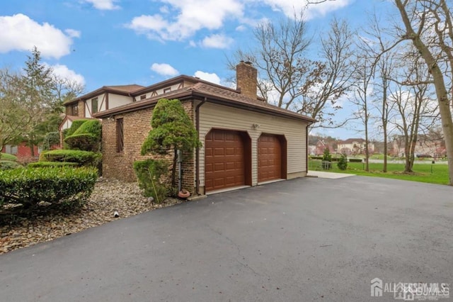 6 Persimmon Ct, East Brunswick, NJ 08816 - view of side of property with a garage, a chimney, asphalt driveway, and brick siding
