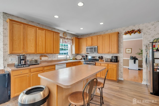 35 Spruce Meadows Dr, Monroe, NJ 08831 - kitchen with appliances with stainless steel finishes, wallpapered walls, light countertops, a kitchen bar, and light wood-type flooring