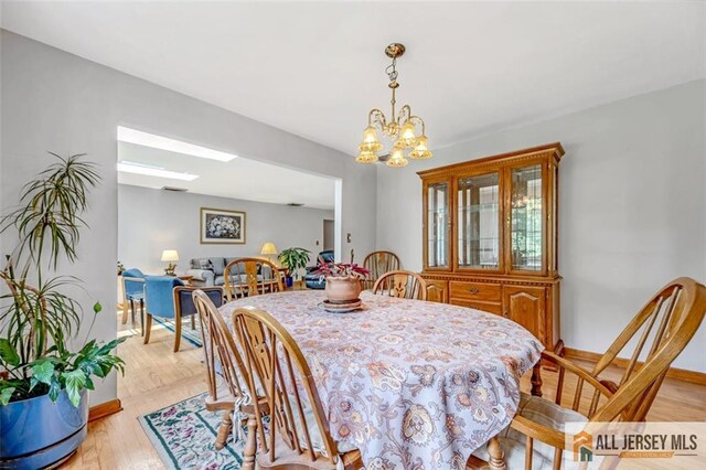 dining space with light wood-type flooring and a chandelier