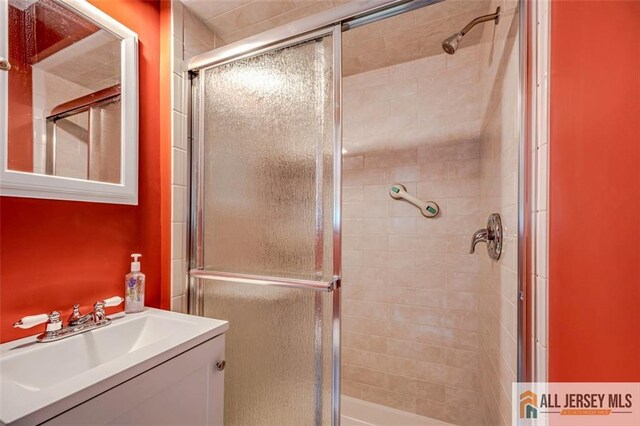 bathroom featuring walk in shower and vanity