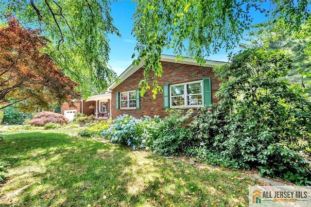 view of property exterior featuring a lawn and brick siding