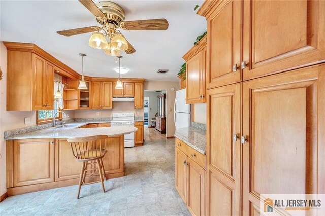 kitchen with ceiling fan, kitchen peninsula, a kitchen bar, sink, and white appliances