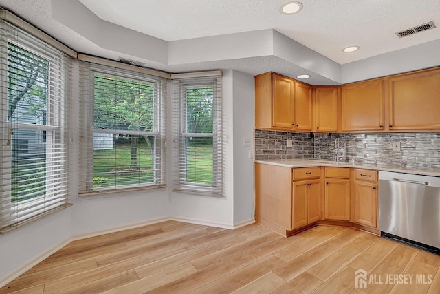 207 Manahan Rd, East Brunswick, NJ 08816 - kitchen with stainless steel dishwasher, light countertops, light wood-style flooring, tasteful backsplash, and recessed lighting