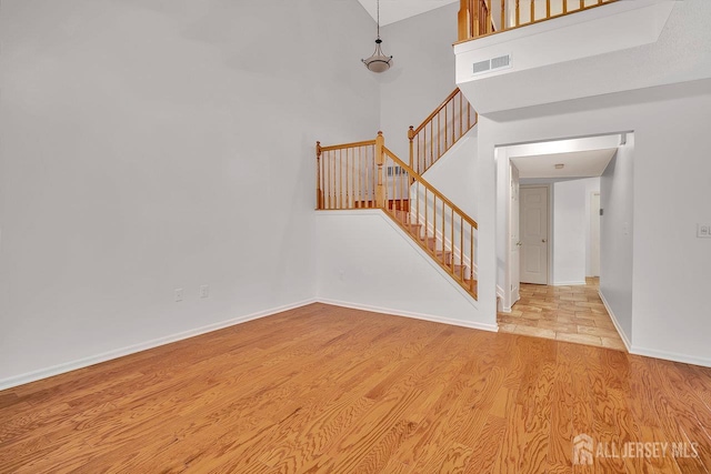 207 Manahan Rd, East Brunswick, NJ 08816 - unfurnished living room with wood finished floors, stairs, and a high ceiling