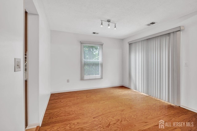 207 Manahan Rd, East Brunswick, NJ 08816 - unfurnished room with a textured ceiling, wood finished floors, and track lighting