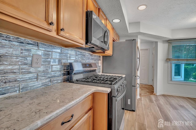 207 Manahan Rd, East Brunswick, NJ 08816 - kitchen with stainless steel gas range oven, light wood-type flooring, a textured ceiling, decorative backsplash, and light stone countertops