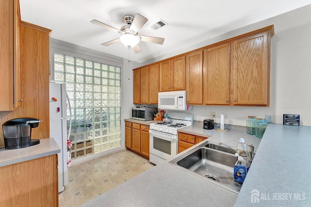 32 Prusakowski Blvd, Sayreville, NJ 08859 - kitchen with white appliances, a ceiling fan, light countertops, and brown cabinetry