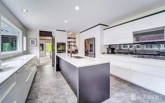 1580 Mountain Top Rd, Bridgewater, NJ 08807 - kitchen featuring modern cabinets, stainless steel fridge, a sink, white cabinetry, and an island with sink