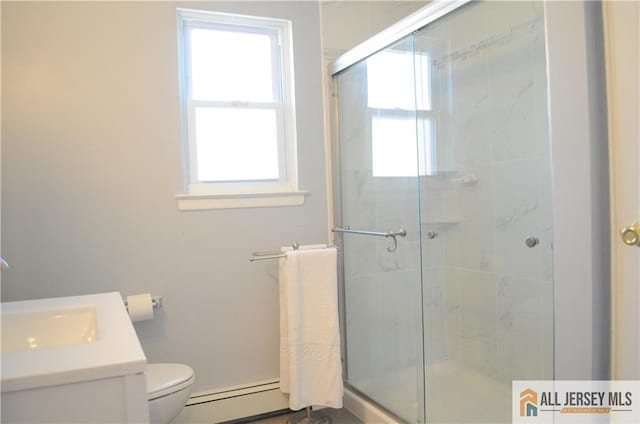 bathroom with vanity, toilet, a shower with shower door, and a baseboard heating unit