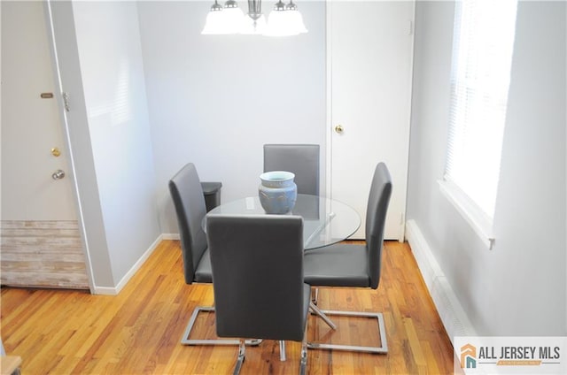 dining area featuring hardwood / wood-style floors and a notable chandelier