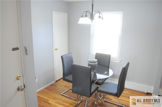 dining space featuring hardwood / wood-style flooring and a notable chandelier