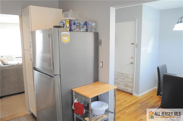 kitchen featuring hardwood / wood-style floors and stainless steel refrigerator