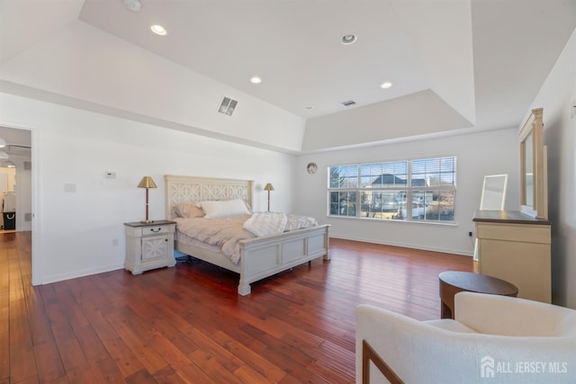 bedroom with dark hardwood / wood-style floors and a tray ceiling