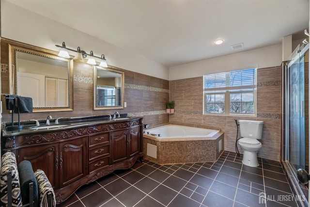 full bathroom featuring tile walls, toilet, vanity, and tile patterned flooring